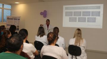 pessoas sentadas em auditorio assistem palestra. #paratodosverem 