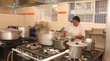 cozinha industrial com mulher trabalhando. #paratodosverem 