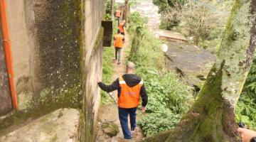 agentes da defesa civil caminham por rua de morro. #paratodosverem 