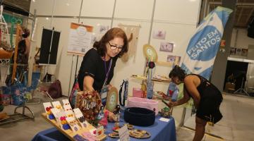 pessoas olham produtos em feira #paratodosverem