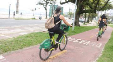 mulher pedala bicicleta do bike santos em ciclovia da orla. #paratodosverem 