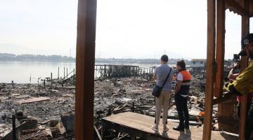 pessoas olham área atingida pelo incêndio #paratodosverem