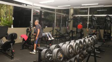 sala de musculação com pessoas se movimentando. #paratodosverem