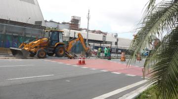 trator quebra e recolhe pedaços do asfalto em canteiro central de avenida. #paratodosverem 