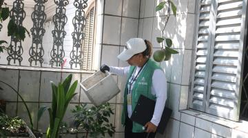 agente da dengue segura recipiente que acumula água. #paratodosverem
