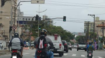 motos paradas em semáforo de avenida. #paratodosverem 