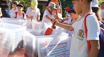 criança mexe em balde de compostagem #paratodosverem