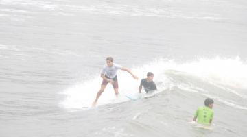 três jovens surfando. #paratodosverem