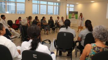 pessoas estão sentadas fazendo uma roda assistindo palestra. #paratodosverem