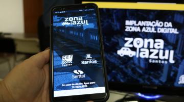 computador e celular estão com aplicativo do zona azul na teça #pracegover 