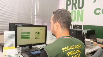 agente do procon uniformizado diante de computador. #paratodosverem