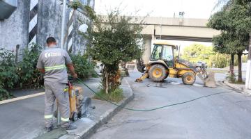 operário usa máquina para operar em calçada. #paratodosverem