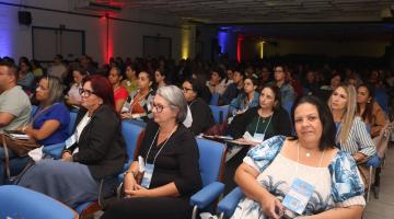pessoas sentadas no auditório lotado #paratodosverem