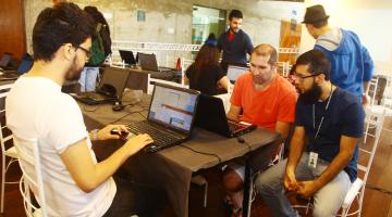 pessoas sentadas na frente de computadores #pracegover 