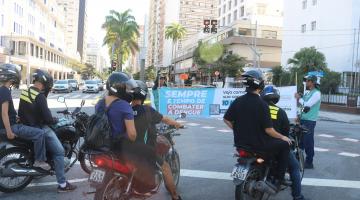 motociclistas parados diante de faixa sobre dengue. #paratodosverem