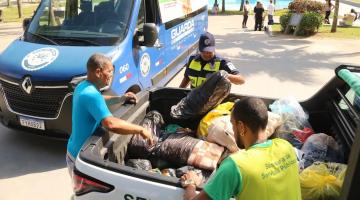 van da guarda municipal na orla ao lado de caminhonete já com vários sacos de roupas. #paratodosverem