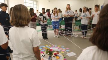 jovens formam rede de conexão com fios de lã. #paratodosverem 