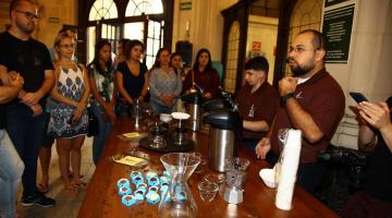 pessoas fazem degustação no museu do café #paratodosverem