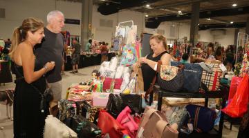 feira de artesanato com clientes e vendedora. #paratodosverem