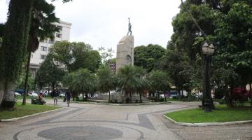 vista geral da praça com árvores e monumento ao fundo. #paratodosverem