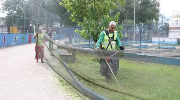 homens usam máquina para cortar grama. #paratodosverem