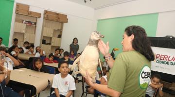 mulher mostra animal empalhado a crianças. #paratodosverem