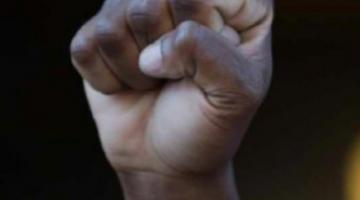 mão de pessoa negra fechada como símbolo de força, resistência. #paratodosverem