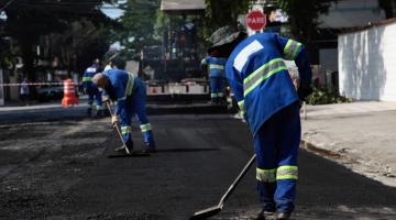 homens trabalham em asfaltamento de rua. #paratodosverem 