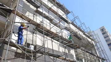 operários em andaimes trabalhando #paratodosverem