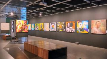 Quadros com imagens de Pelé pendurados em paredes pretas. #pracegover
