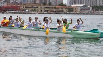 Voluntário remam em canoa havaiana. #pracegover