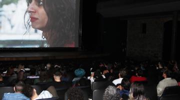 Atriz santista no telão assistido pelo público que lotou o teatro. #paratodosverem