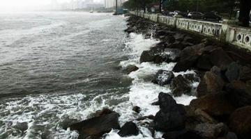 mar batendo nas pedras atrás da mureta da ponta da praia. #paratodosverem