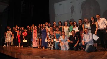 Grupo de formados e orientadores no palco do Teatro Guarany. #pratodosverem