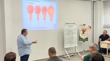 servidores acompanham palestra sentados #paratodosverem 