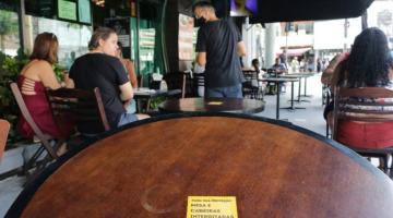 #pracegover foto mostra mesa vazia e outras com clientes em restaurante
