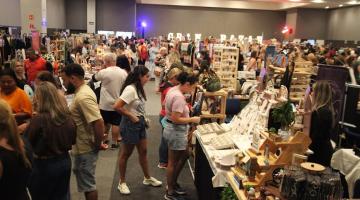 pessoas olhando estandes na feira #paratodosverem 