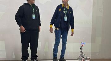 alunos com robô no palco #paratodosverem 