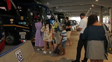 pessoas fazem fila para entrar em ônibus parado em baia na rodoviária. Há outros ônibus ao fundo. #paradodosverem