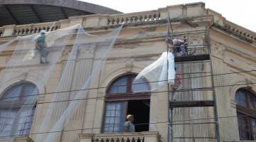 pessoas trabalhando em andaimes na fachada do teatro #paratodosverem