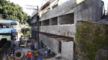 Vista lateral da construção de  nova escola, com três pavimentos em concreto em evidência. #Pracegover