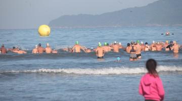 nadadores no mar e criança observa #paratodosverem