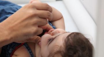 Criança recebe dose de vacina. #paratodosverem
