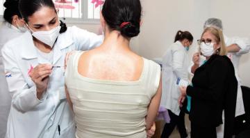 Enfermeira aplica vacina em mulher #paratodosverem