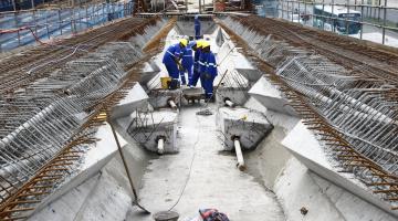 operários reunidos no meio do viaduto em obras #pracegover 