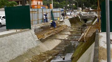 Vista geral de canal com estrutura de ferro ao fundo aguardando a concretagem. #Pracegover