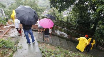 Equipe da defesa civil em morro junto a moradores. #Paratodosverem