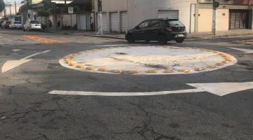 Rotatória com pintura de solo indicando o sentido de movimento. Carro atravessa a rua. #Paratodosverem