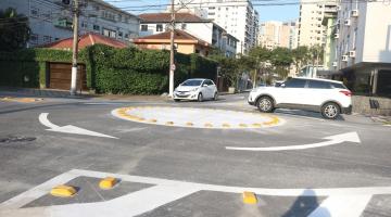 Rotatória implementada no solo com sinalização. Um carro faz o cruzamento e outro aguarda. #paratodosverem