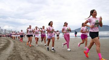Mulheres correndo nas areias da praia de Santos. #Paratodosverem